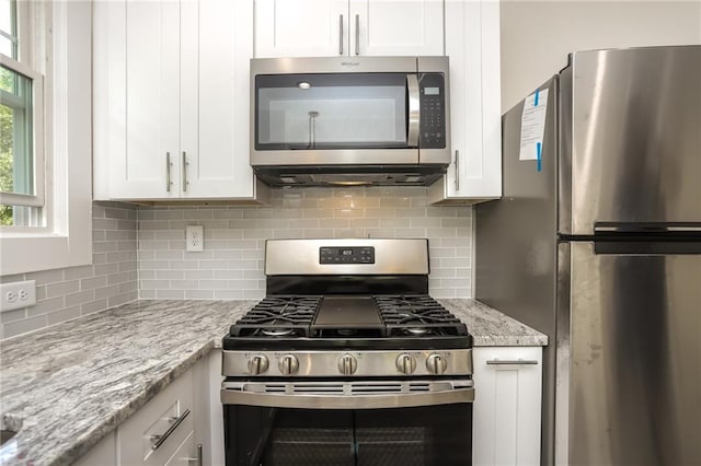 kitchen featuring appliances with stainless steel finishes, decorative backsplash, and white cabinets