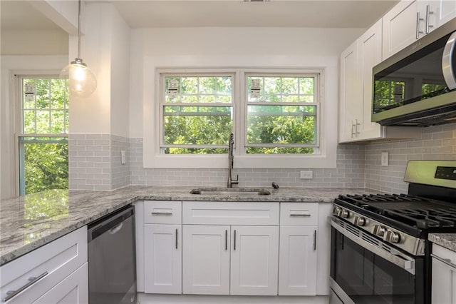 kitchen with stainless steel appliances, light stone countertops, sink, and white cabinets