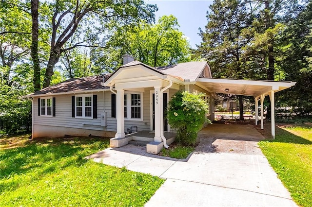 view of front of property featuring an attached carport, a chimney, concrete driveway, and a front lawn