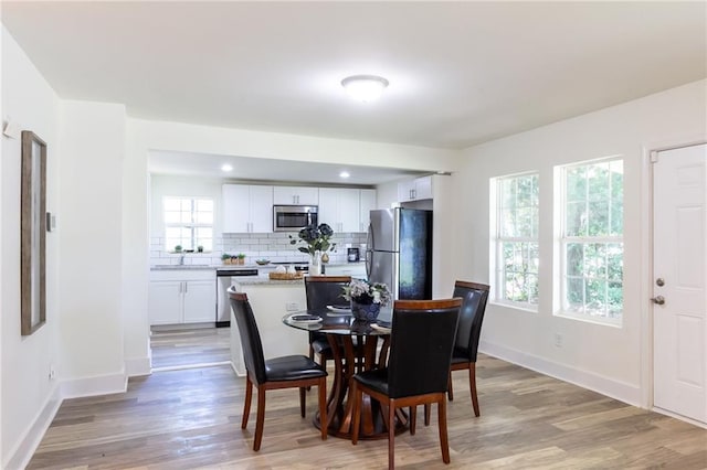 dining space with recessed lighting, baseboards, and light wood-style floors
