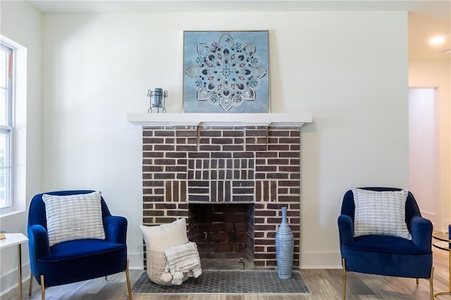 sitting room featuring baseboards, wood finished floors, and a fireplace