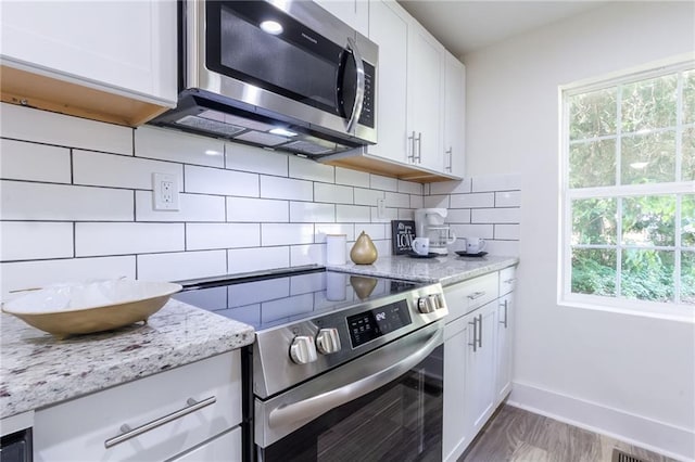 kitchen featuring decorative backsplash, plenty of natural light, appliances with stainless steel finishes, and white cabinetry