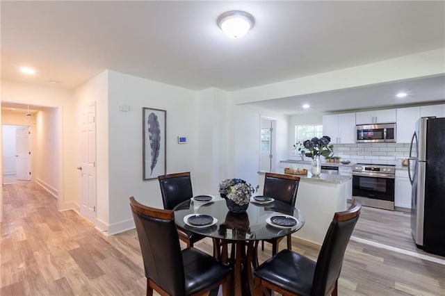 dining space featuring recessed lighting, baseboards, and light wood-style floors