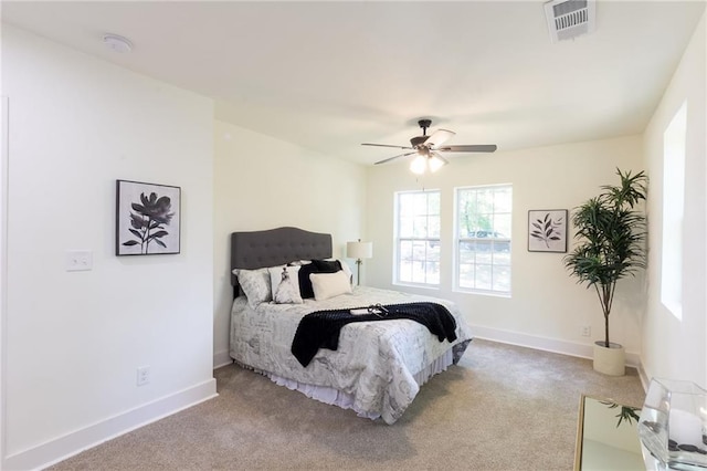 bedroom featuring ceiling fan, light colored carpet, visible vents, and baseboards