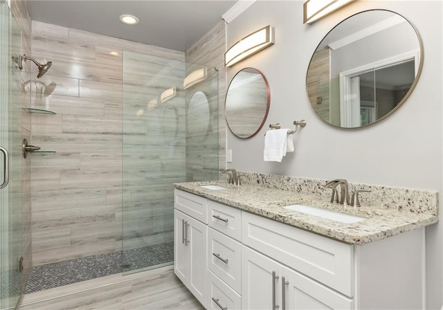 full bath with recessed lighting, a sink, a stall shower, and double vanity