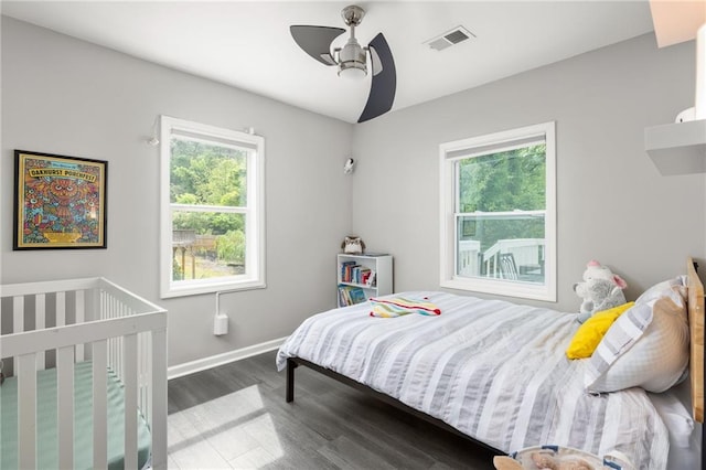 bedroom featuring visible vents, baseboards, ceiling fan, and wood finished floors