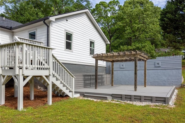 rear view of house featuring a lawn, a pergola, and a deck