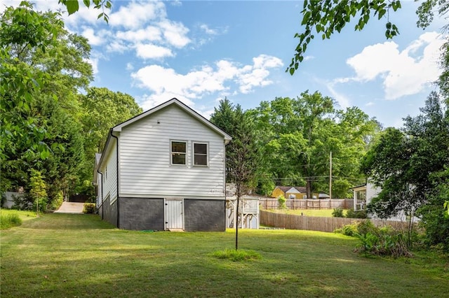 view of property exterior featuring a yard and fence
