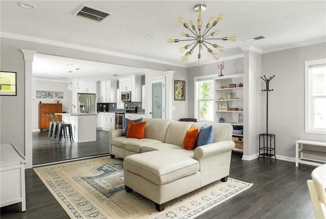 living area with an inviting chandelier, decorative columns, dark wood-style floors, and visible vents