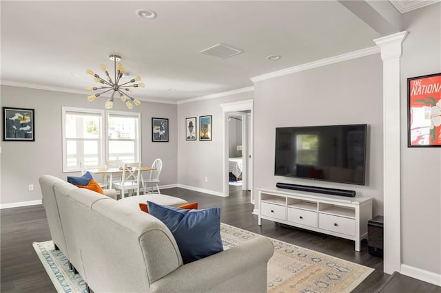 living area with crown molding, an inviting chandelier, dark wood finished floors, baseboards, and ornate columns