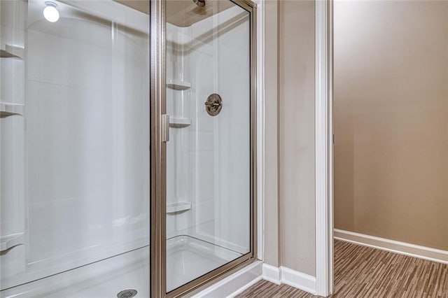 bathroom with wood-type flooring and an enclosed shower