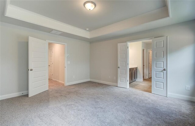 interior space with sink, coffered ceiling, a center island with sink, and light hardwood / wood-style floors