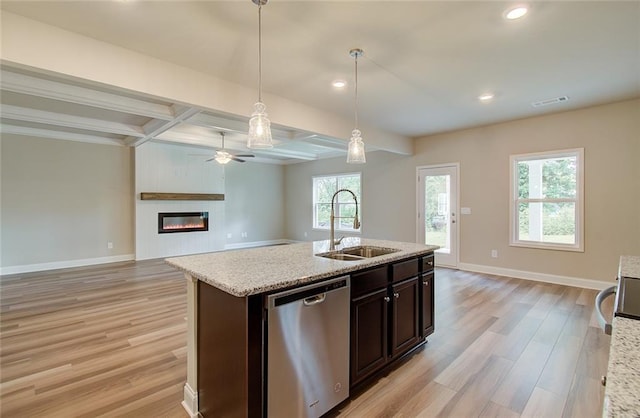 kitchen featuring sink, hanging light fixtures, dark brown cabinetry, light stone countertops, and stainless steel dishwasher