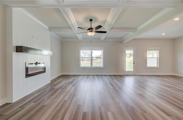 unfurnished living room featuring beamed ceiling, a fireplace, coffered ceiling, and light hardwood / wood-style flooring