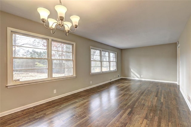 unfurnished room featuring dark wood-type flooring and a notable chandelier