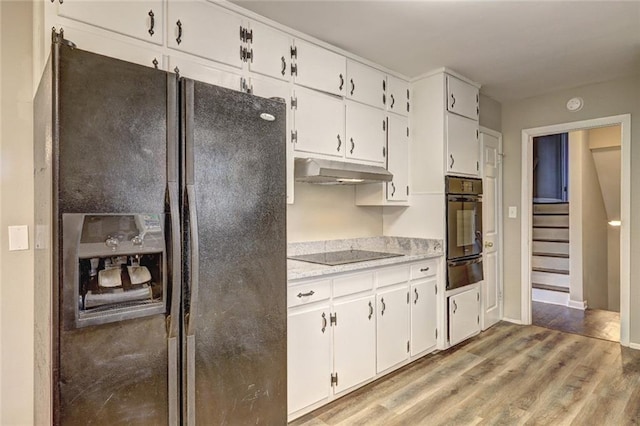 kitchen featuring light hardwood / wood-style flooring, white cabinetry, and black appliances