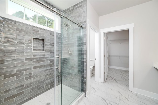 full bath with a shower stall, toilet, marble finish floor, a walk in closet, and baseboards