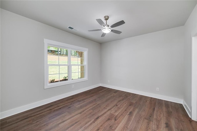 spare room with dark wood-type flooring, ceiling fan, baseboards, and visible vents