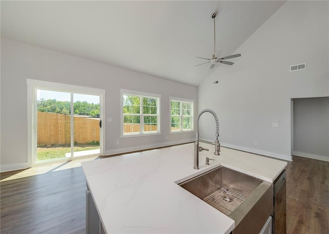 kitchen featuring ceiling fan, dark wood-type flooring, visible vents, a sink, and open floor plan