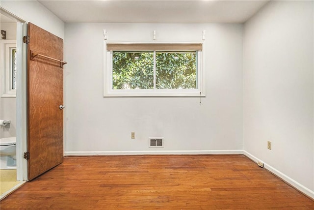 unfurnished bedroom featuring wood finished floors, visible vents, and baseboards