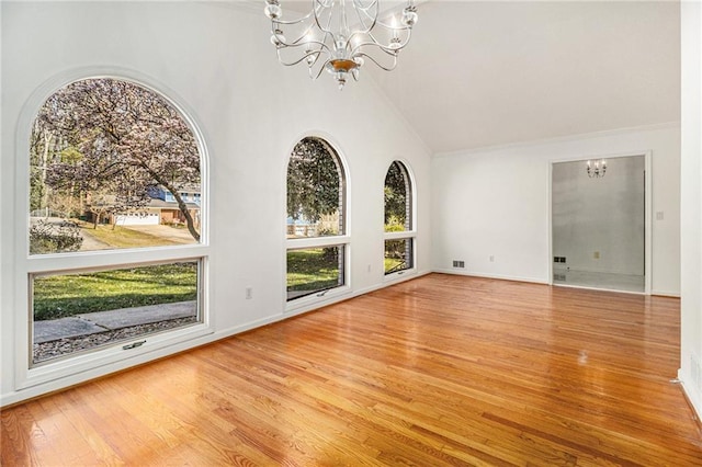 unfurnished room featuring wood finished floors, baseboards, visible vents, high vaulted ceiling, and an inviting chandelier