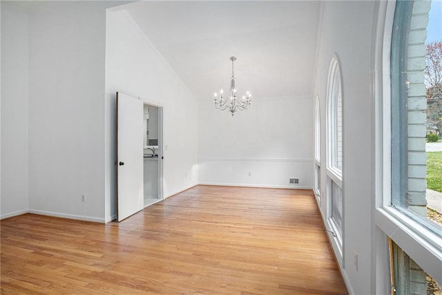 unfurnished room featuring baseboards, light wood-style floors, visible vents, and a chandelier