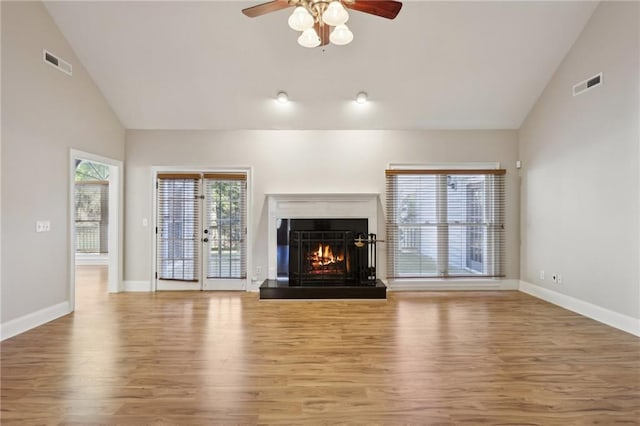 unfurnished living room with ceiling fan, french doors, high vaulted ceiling, and wood-type flooring