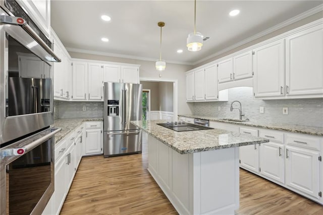 kitchen with pendant lighting, white cabinets, sink, and stainless steel appliances