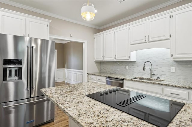 kitchen with sink, white cabinets, hanging light fixtures, and appliances with stainless steel finishes