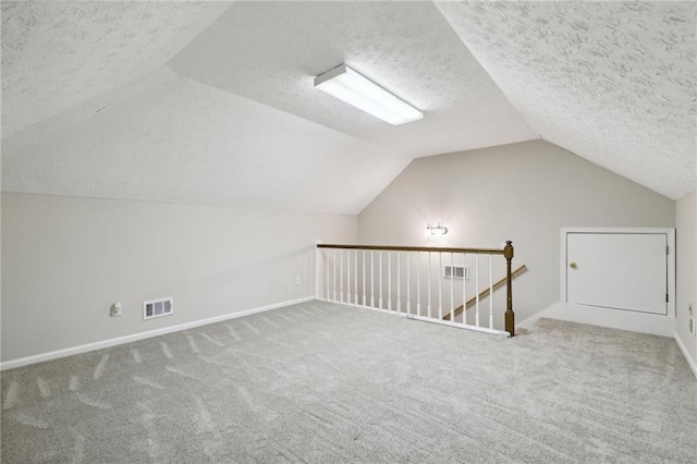 additional living space with carpet flooring, a textured ceiling, and lofted ceiling