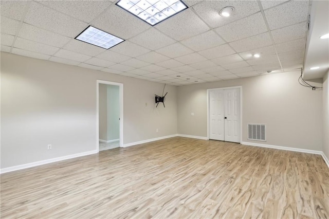 living room featuring a paneled ceiling and light hardwood / wood-style floors