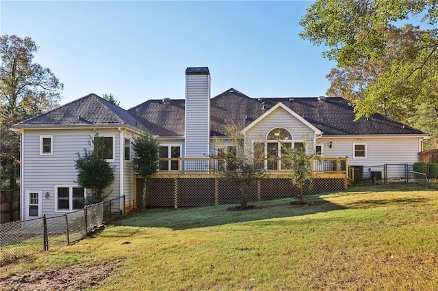 back of house featuring a lawn and a wooden deck