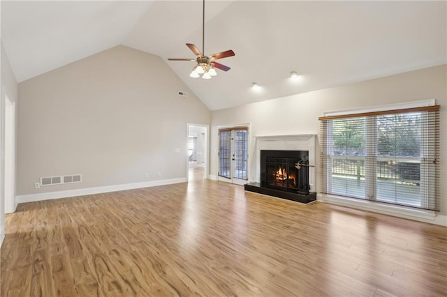 unfurnished living room with ceiling fan, light wood-type flooring, and high vaulted ceiling