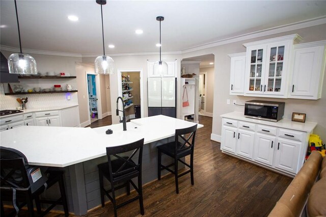 200 Carney Ct, Ball Ground, GA 30107 - kitchen featuring light countertops, stainless steel microwave, white cabinets, and a kitchen bar