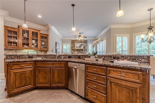 kitchen with pendant lighting, stone countertops, dishwasher, and sink