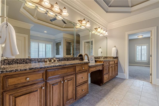 bathroom with tile patterned flooring, ornamental molding, vanity, and a tray ceiling