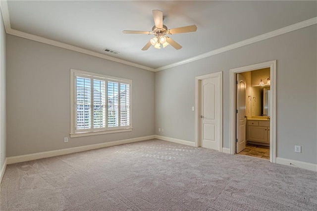 unfurnished bedroom featuring crown molding, light colored carpet, ceiling fan, and ensuite bathroom