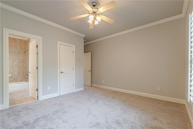 unfurnished bedroom featuring ceiling fan, ensuite bathroom, light colored carpet, and ornamental molding