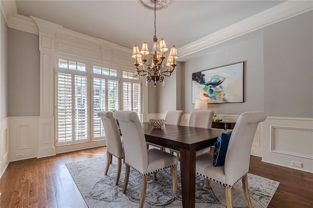 dining area with ornamental molding, a chandelier, and dark hardwood / wood-style flooring