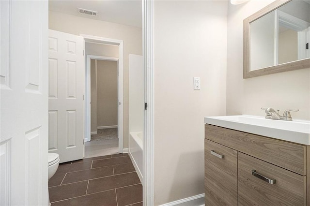 bathroom with vanity, a bathing tub, tile patterned floors, and toilet