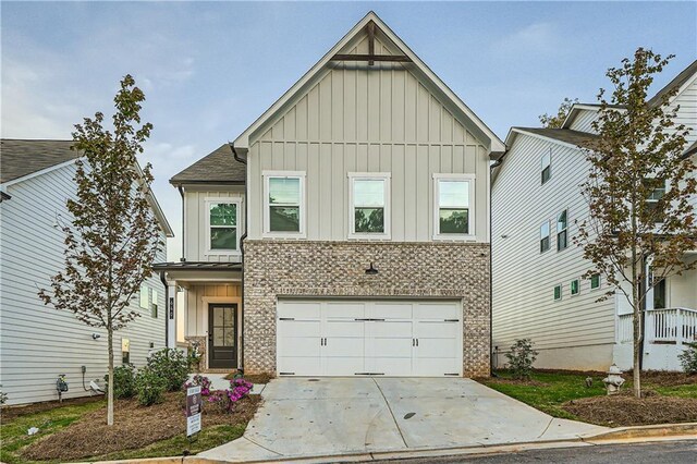 view of front of home featuring brick siding, board and batten siding, an attached garage, and driveway