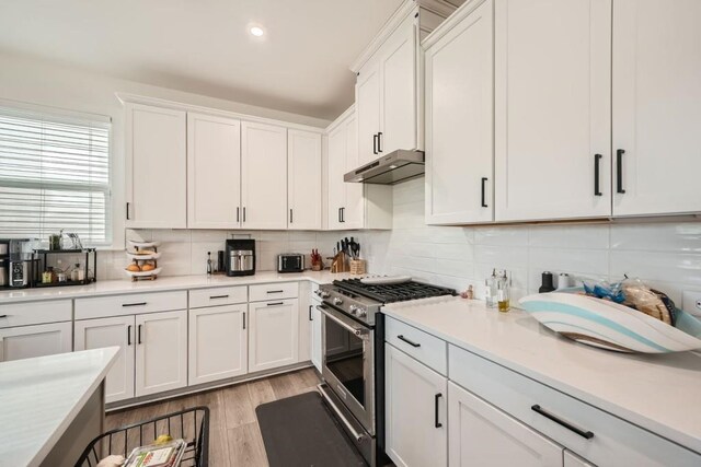 kitchen featuring freestanding refrigerator, light countertops, white cabinetry, light wood-type flooring, and backsplash