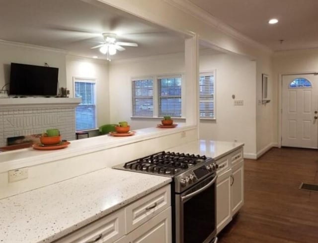 kitchen with gas range, ceiling fan, crown molding, white cabinets, and dark hardwood / wood-style floors