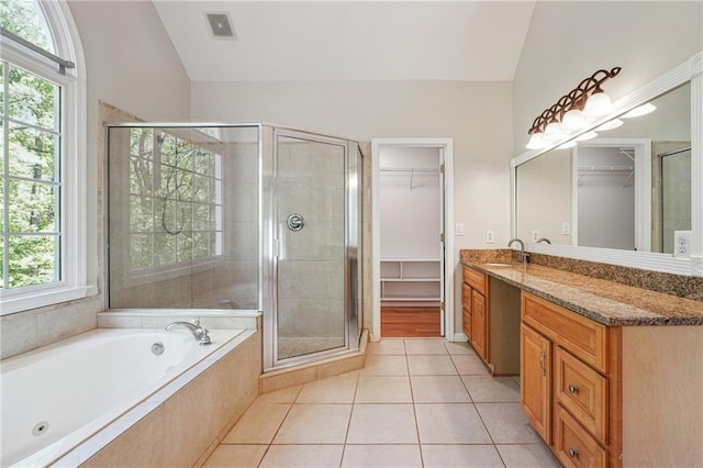 bathroom featuring a shower stall, vaulted ceiling, tile patterned floors, a spacious closet, and vanity