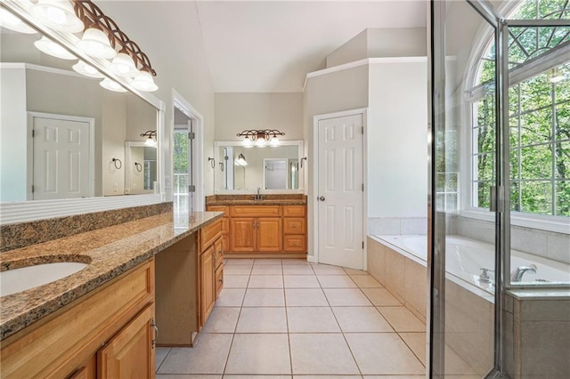 bathroom with a bath, a wealth of natural light, tile patterned flooring, and vanity