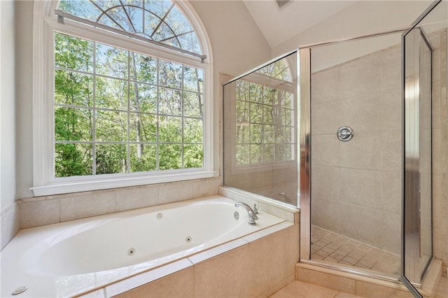 full bath featuring lofted ceiling, a jetted tub, and a stall shower