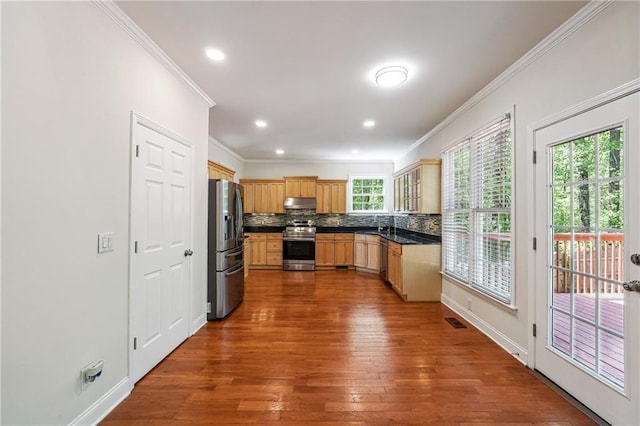 kitchen featuring stainless steel appliances, dark wood-style floors, tasteful backsplash, crown molding, and under cabinet range hood