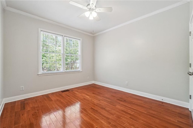 spare room with hardwood / wood-style floors, a ceiling fan, baseboards, and visible vents