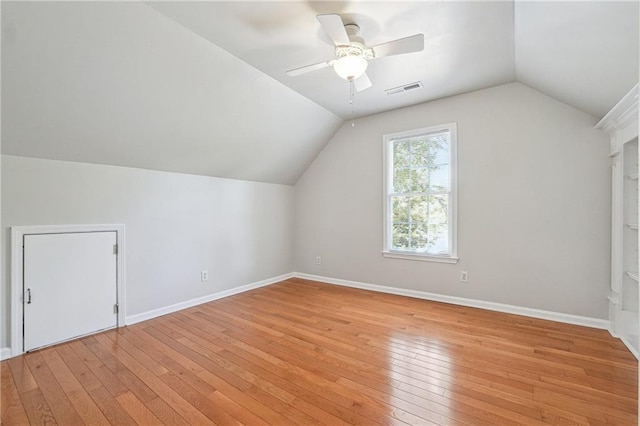 additional living space with baseboards, lofted ceiling, a ceiling fan, and light wood-style flooring