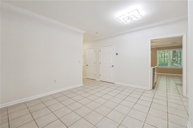 empty room with baseboards, ornamental molding, and light tile patterned floors
